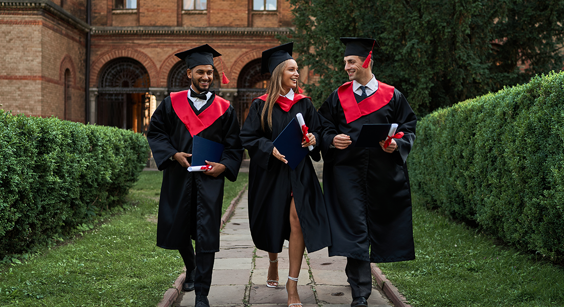 three-gradutes-friends-graduation-gowns-walking-campus