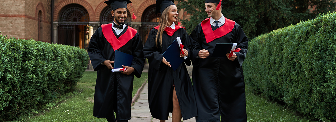 three-gradutes-friends-graduation-gowns-walking-campus